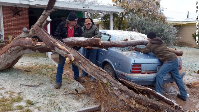A man in Texas attempts to move a tree off of his car. 11/26/13 Photo By: CNN